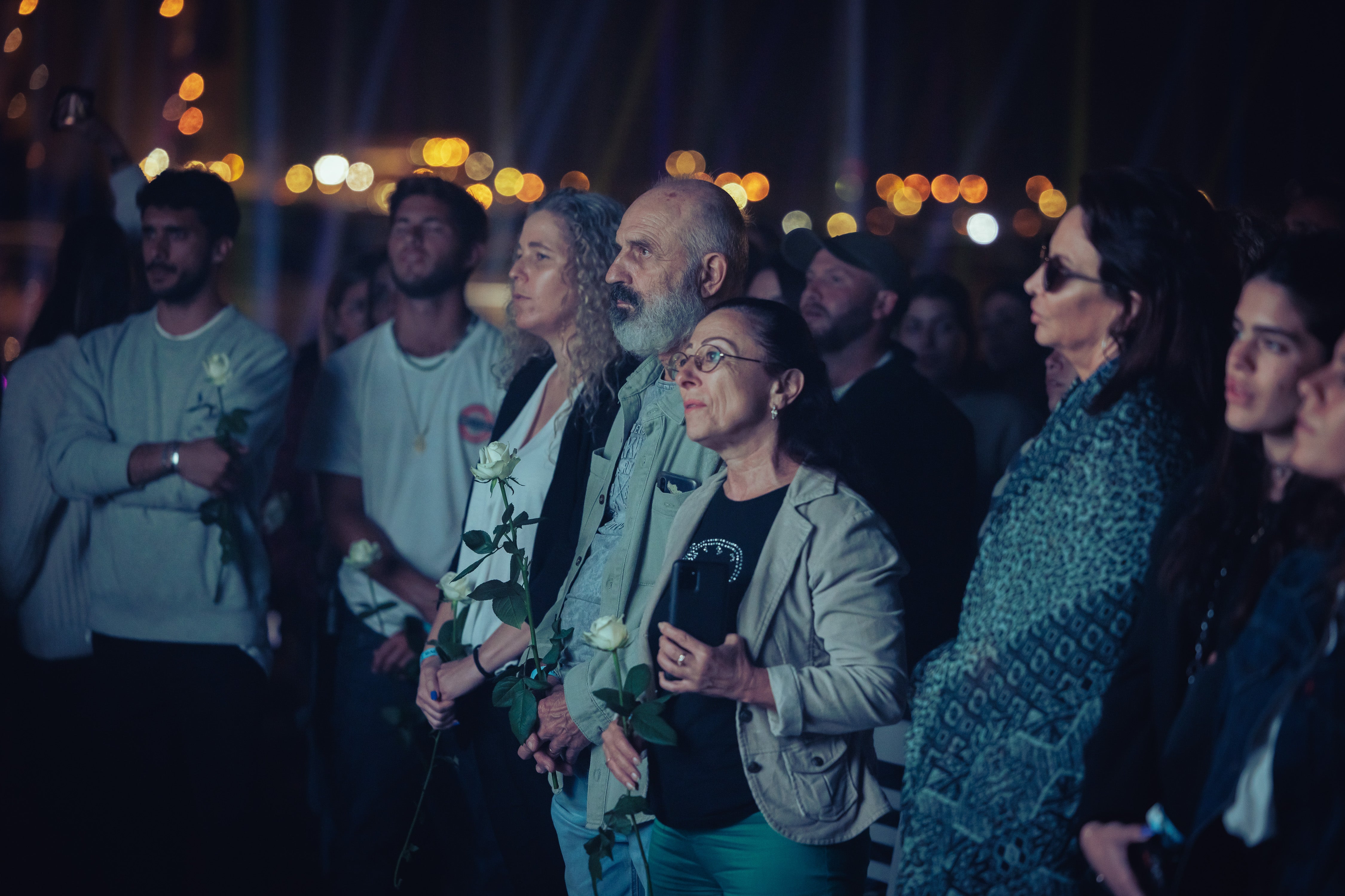 The Nova community gathered together, holding white roses